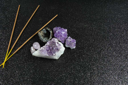 Amethyst crystals and incence with black background