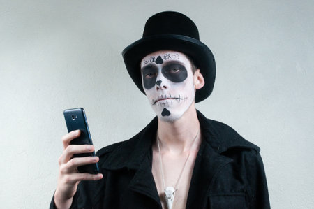 man with skull and skeleton in halloween costumeの写真素材