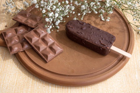 Chocolate posicle on the table with white flowers aroundの写真素材