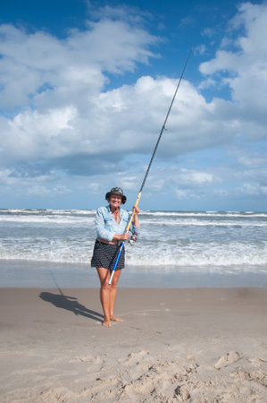 Old lady fishing on the beachの写真素材