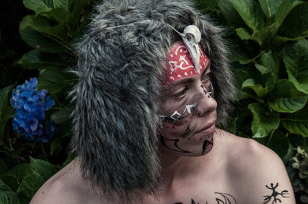 Portrait of a boy with painted face and red bandage on her head