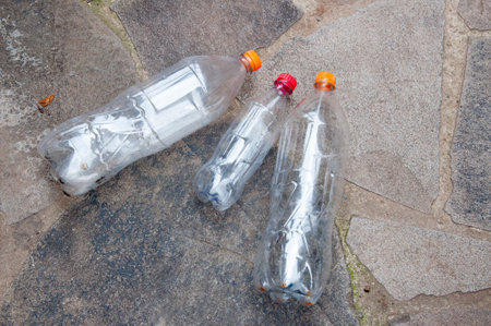 Plastic bottles on the sidewalk. Recycling problem concept.