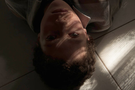 Young man lying on the floor with his eyes closed. View from above.の写真素材