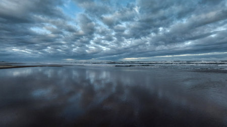 Panorama of a stormy sea at low tide with dark cloudsの写真素材