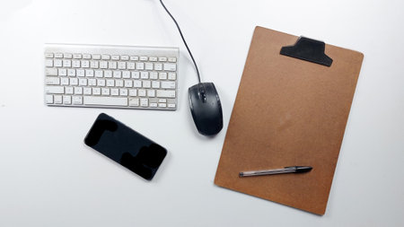 Keyboard, mouse, notepad and pen on a white backgroundの写真素材