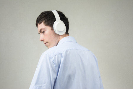 Portrait of a young man listening to music with headphones on the street