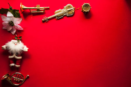Christmas background with santa claus, trumpet and flowers on red backgroundの写真素材