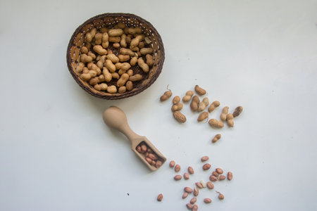 Peanut in a wooden bowl on a white background. Selective focus.の写真素材