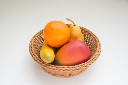 fruits in a basket on white background, healthy food.の写真素材