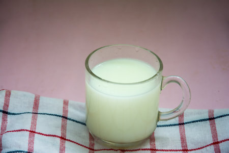 Milk in a glass on a red and white checkered tablecloth
