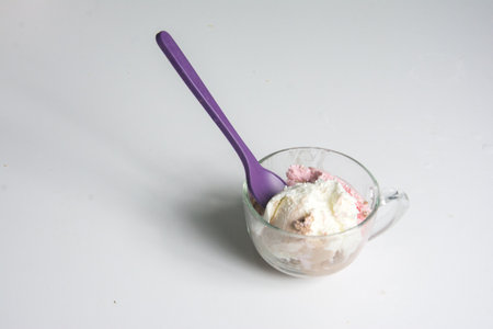 ice cream in a glass cup with a spoon on a white backgroundの写真素材