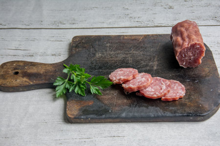 slices of salami on a cutting board with parsley