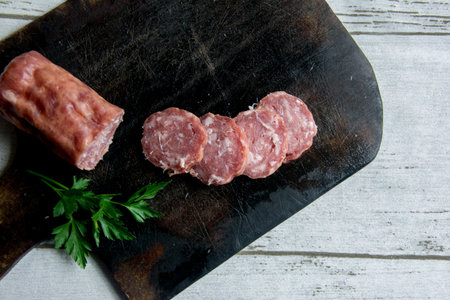 sliced salami, cheese on a wooden board. Top view