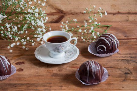 Chocolate candies and cup of coffee on a wooden background.の写真素材