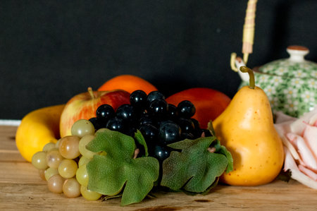 Still life with fresh fruits on a wooden table. Black background.の写真素材