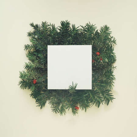 Christmas tree branches on a beige background with a note card. Flat lay party concept.の写真素材