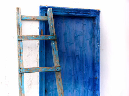 Blue ladder leaning against the blue doorの写真素材