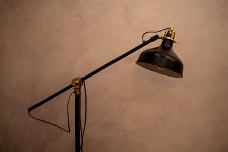 Table lamp with articulated arm on a brown background.
