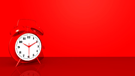 Red alarm clock against a red backgroundの写真素材
