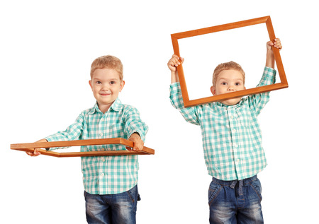 Happy kid holding a wooden picture frame on white backgroundの写真素材