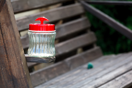 Empty jar whith red plastic cover on a  wooden boardの写真素材