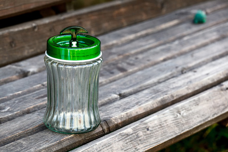 Empty jar with green plastic cover on a  wooden boardの写真素材