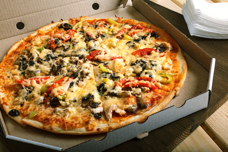 Delicious hot italian pizzas in box with tomato, mushrooms, garlic and pepperの写真素材
