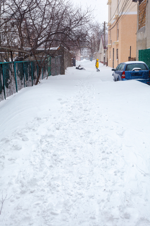 A street in city after a snow storm. Cars and buildings can be seenの写真素材