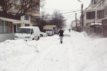 Winter street with lots of snow and walking woman in Odessaの写真素材