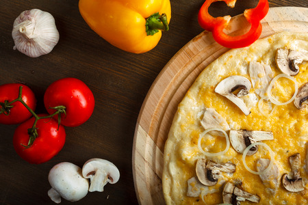 Delicious hot italian pizzas served on wooden table with tomato, mushrooms, garlic and pepperの写真素材