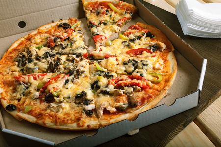 Delicious hot italian pizzas in box with tomato, mushrooms, garlic and pepperの写真素材