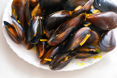 Steamed black sea mussels in cream sauce with carrotの写真素材