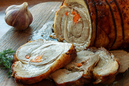 Pork roll with roasted vegetables on wooden boardの写真素材