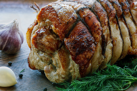Roasted pork roll stuffed with vegetables on wooden boardの写真素材