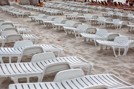 Beach chairs in the low season. Empty sunbeds on a sandy beachの写真素材