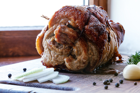Roasted pork roll stuffed with vegetables on wooden board.の写真素材