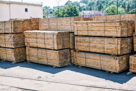 stacked piles of timber product at railroad cargo areaの写真素材