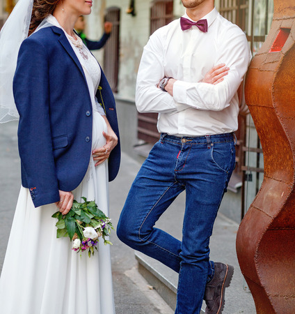 Pregnant Bride and groom on their wedding day outdoors.の写真素材