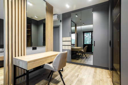Modern luxury bedroom in loft style with dark and grey style. Dark headboard and wooden floor with wall panelの写真素材