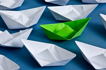 White paper boats and one green boat の写真素材