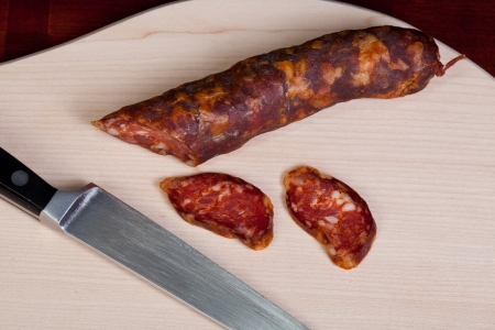 Sausage with knife on wooden boardの写真素材