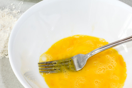 Mixe  egg with fork inside plateの写真素材