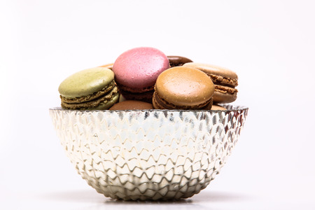 Colored macarons inside bowl on white backgroundの写真素材