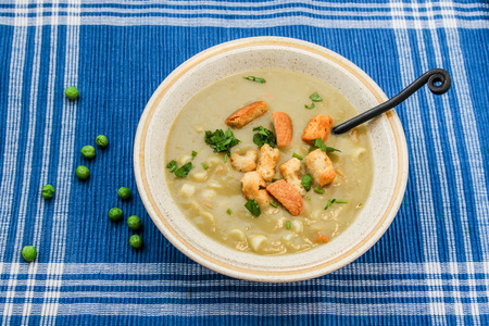 Pea soup with macaroons  and croutons with peas aroundの写真素材