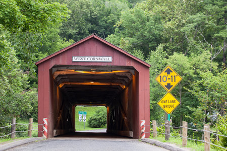 WEST CORNVALL, CONNECTICUT - JULY 15, 2015: The 1864 West Cornwall Covered Bridge. also known as Hart Bridge, is a wooden lattice truss bridge over the Housatonic River on July 15, 2015 in West Cornwall, CT, USA.のeditorial素材