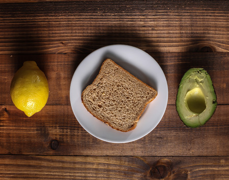 Table with lemon, avocado and breadの写真素材