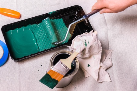 Hand with paint roller and green paintHand with paint roller and green paintHand with paint roller and green paintの写真素材