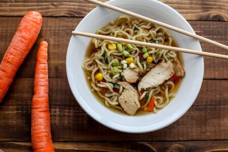 Shoyu chicken Tokyo style ramen soup with carrots on wooden rustic table topの写真素材