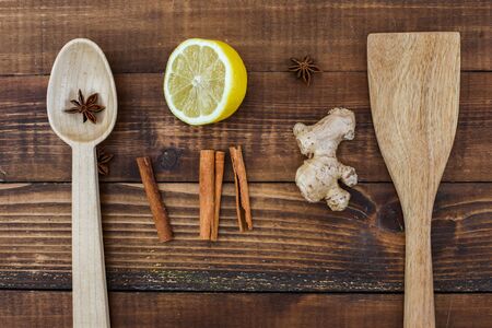 Wooden table top view with wooden spoons and tea ingredients