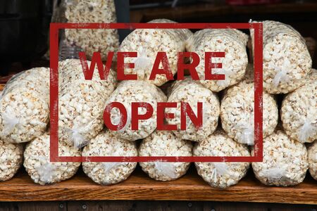 Popcorn in plastic bags with we are open text